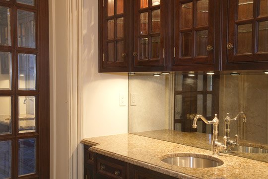 Mahogany wet bar with glazed cabinetry and granite counter