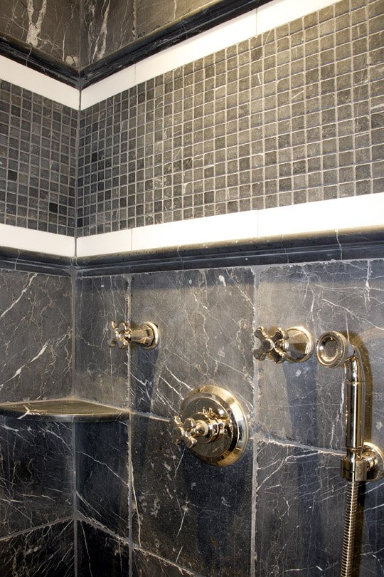Marble and mosaic tiled shower with polished brass fittings