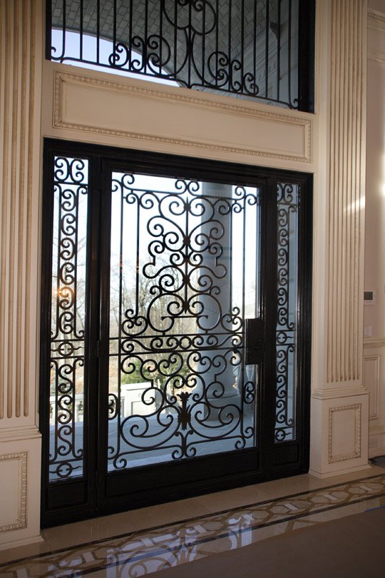 Wrought iron and glass double entry doors with transom in an Alliotts home