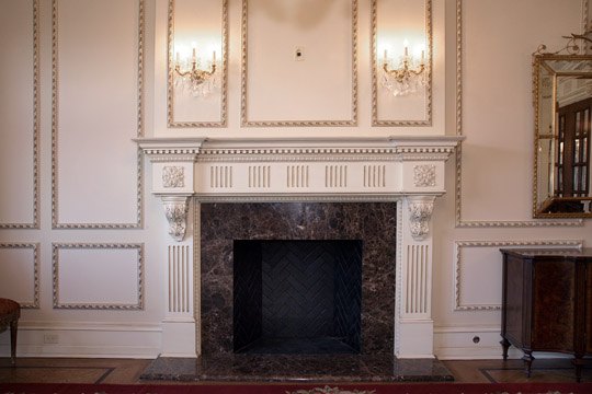 Panelled reception room with marble mantel and applied moulding in an Alliotts home